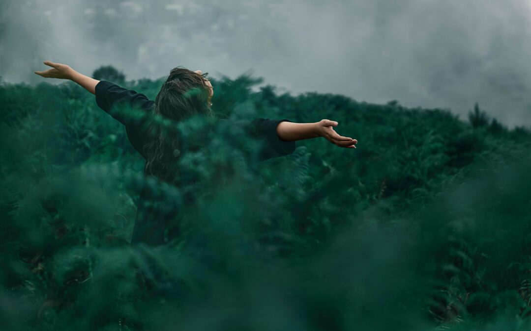 Femme dans la nature, bras ouverts.